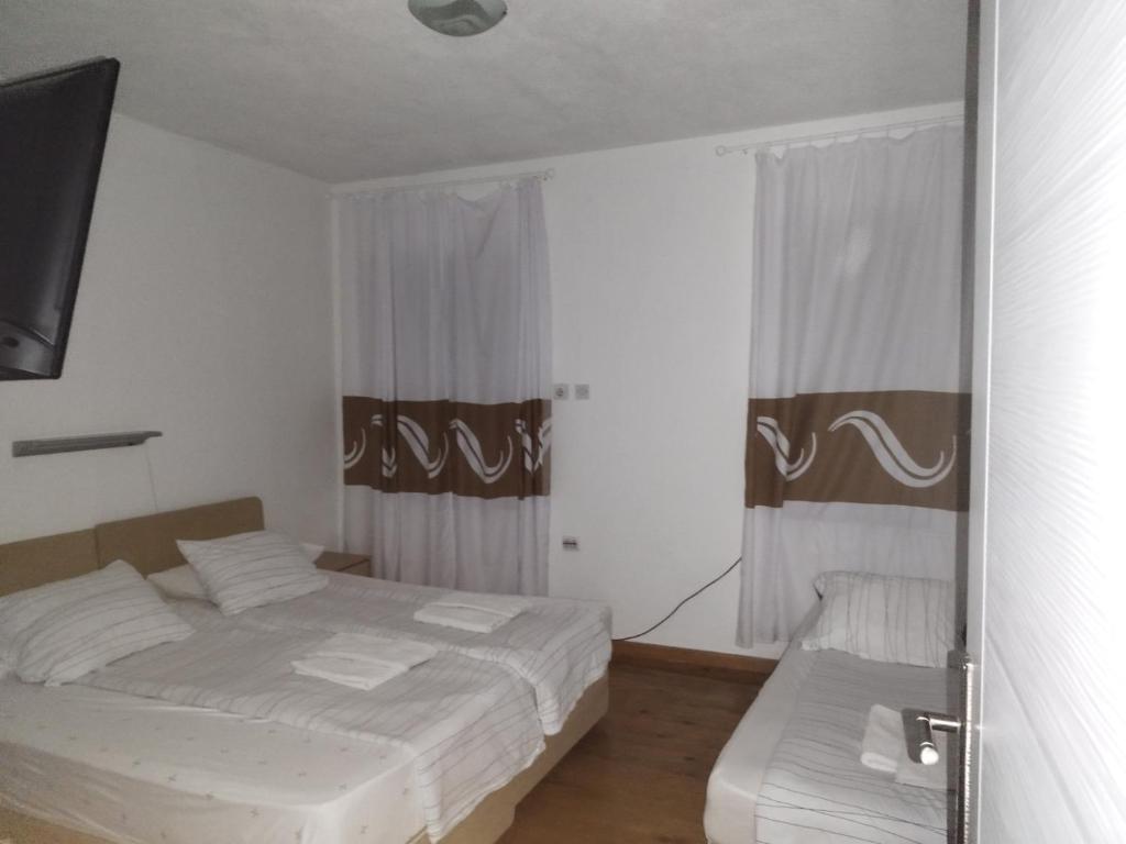a bedroom with two beds and a television in it at Bilyana Apartments in Ohrid
