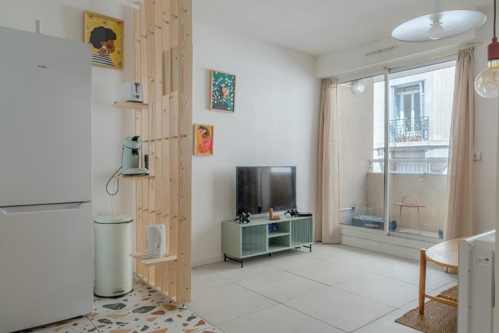 un salon avec une télévision et une fenêtre dans l'établissement Charmant T2 avec balcon - Chaves, à Marseille
