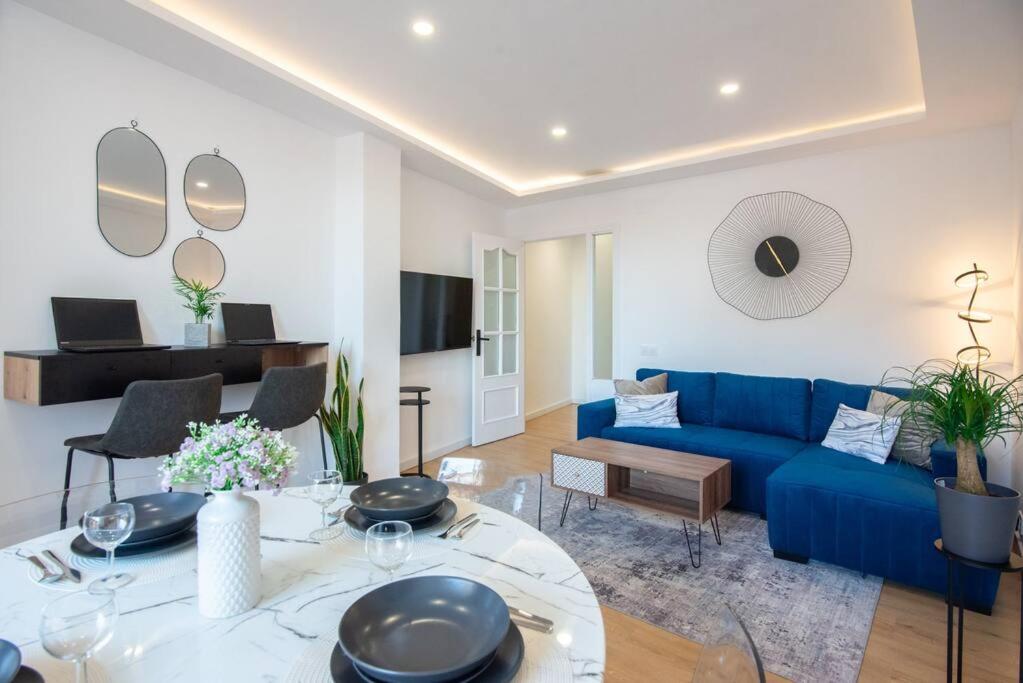 ein Wohnzimmer mit einem blauen Sofa und einem Tisch in der Unterkunft +25Y ONLY, Family flat near the beach in Barcelona