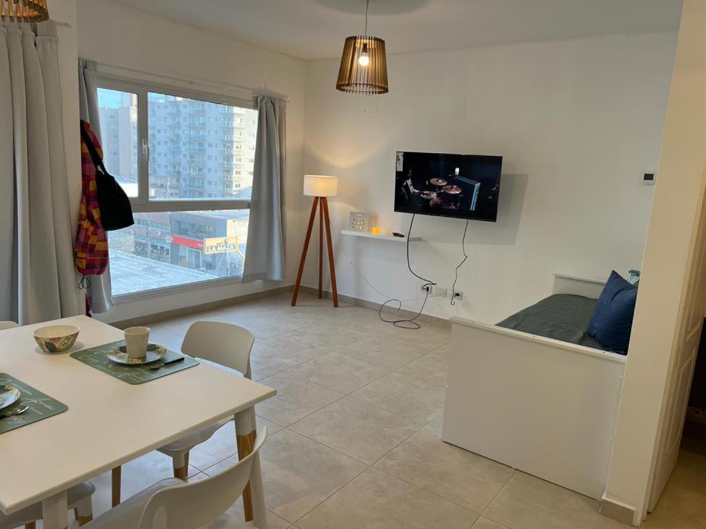 a living room with a table and a tv on the wall at Depto 1 dormitorio vista al mar!! in Puerto Madryn
