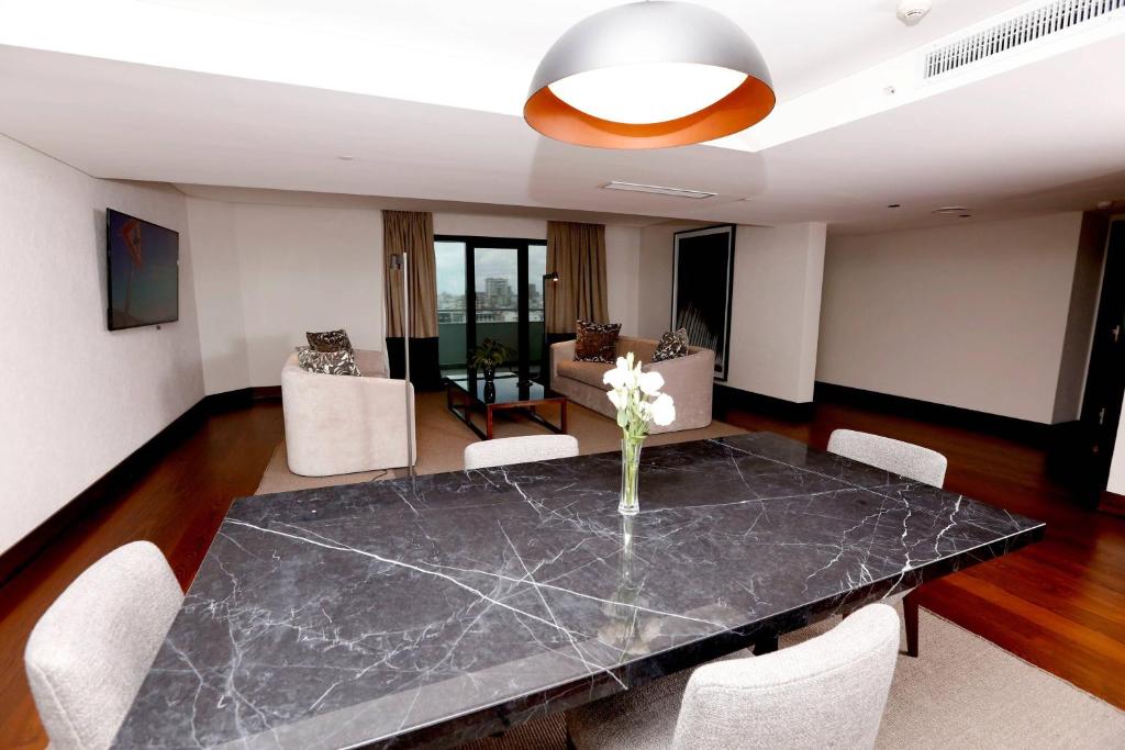 a dining room with a black marble table and white chairs at Buenos Aires Marriott in Buenos Aires