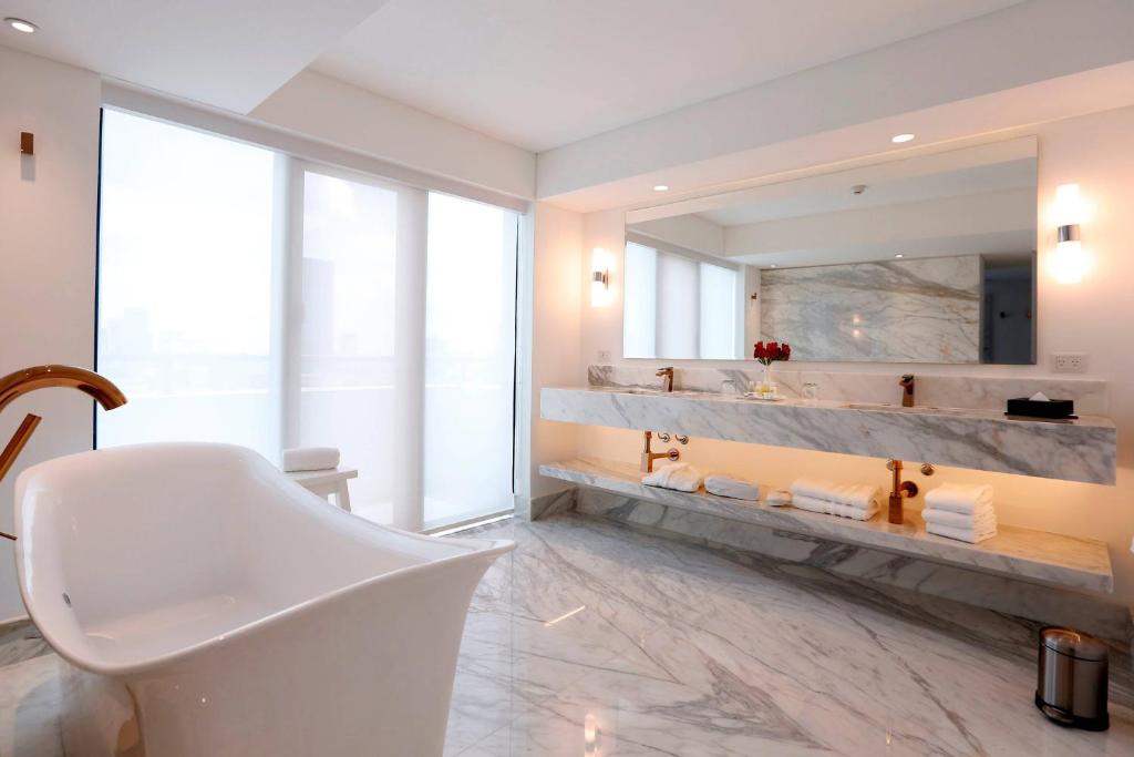 a bathroom with a white tub and a large mirror at Buenos Aires Marriott in Buenos Aires
