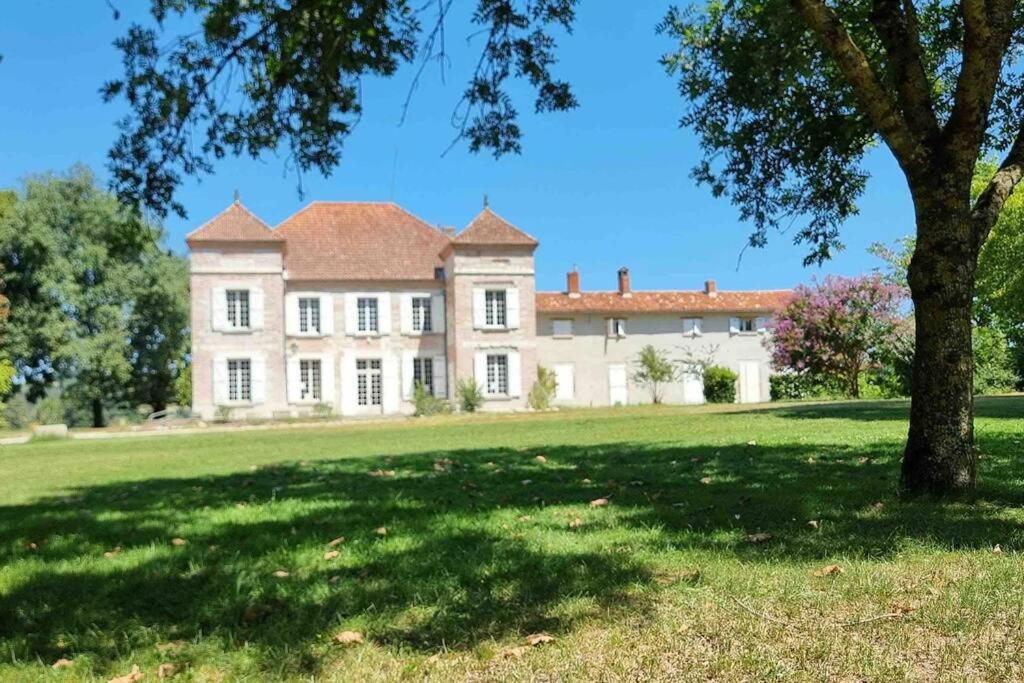 ein großes Haus mit einem Baum auf einem Feld in der Unterkunft Château d'Issandou in Golfech