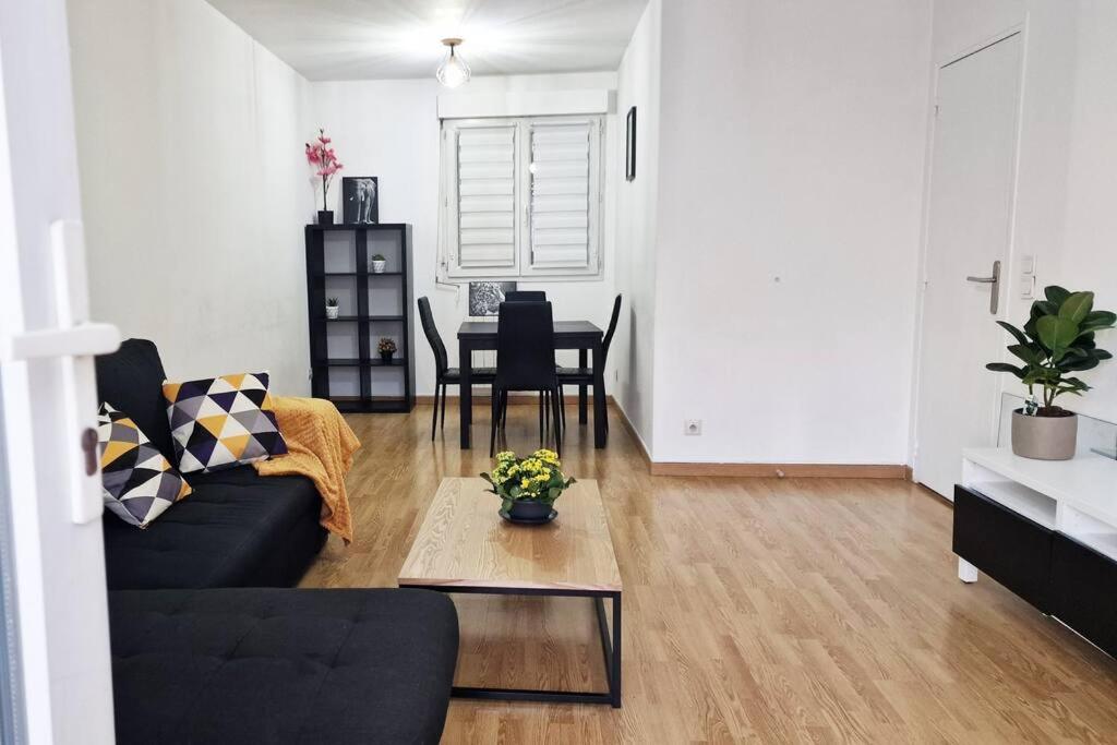 een woonkamer met een bank en een tafel bij Appart Cosy & Spacieux-Métro7 Louis-Aragon+Parking in Vitry-sur-Seine