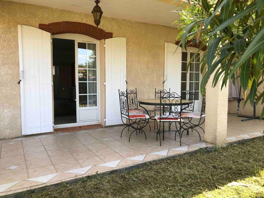 a patio with a table and chairs on a house at Villa Bonheur secteur Blagnac 9 pers Netflix Wifi in Mondonville