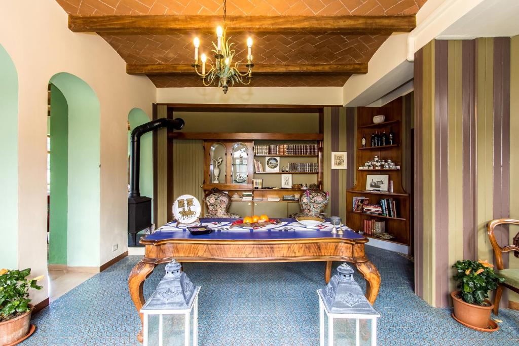 una sala da pranzo con tavolo e lampadario pendente di Villa la Ginestra - Charming Country Rooms a Subbiano