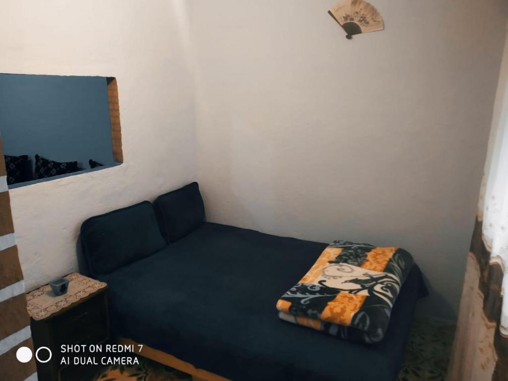 ein kleines Zimmer mit einem Bett und einem Sofa in der Unterkunft شفشاون in Aït Saïd