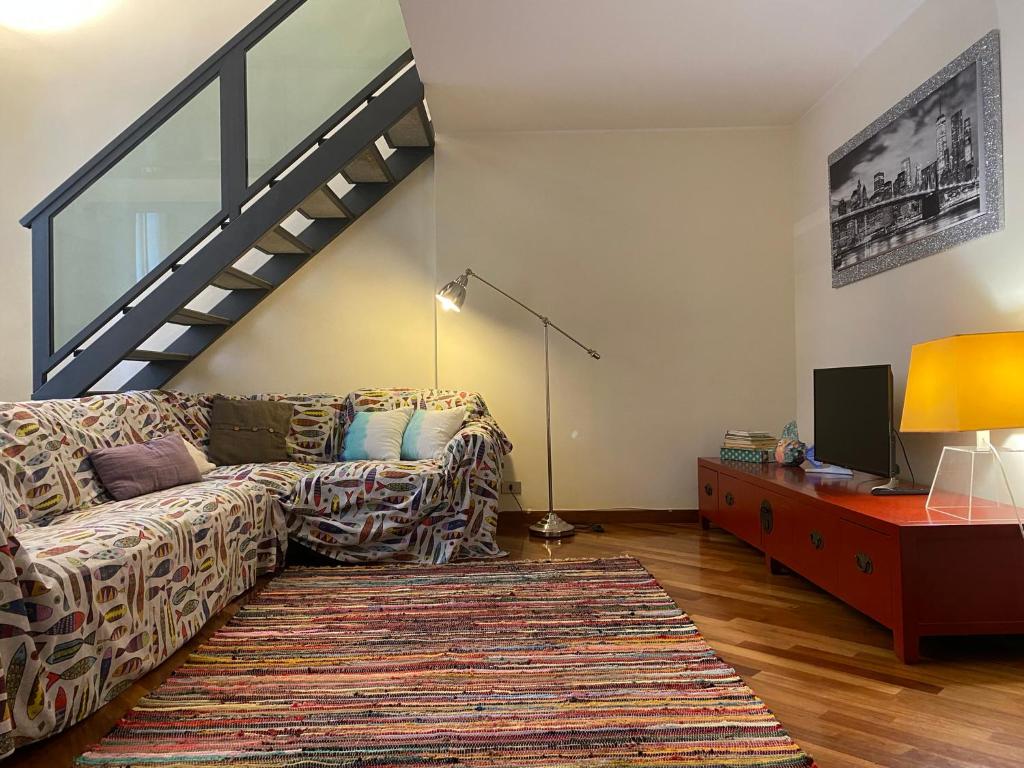a living room with a couch and a staircase at Casa vela in Turin