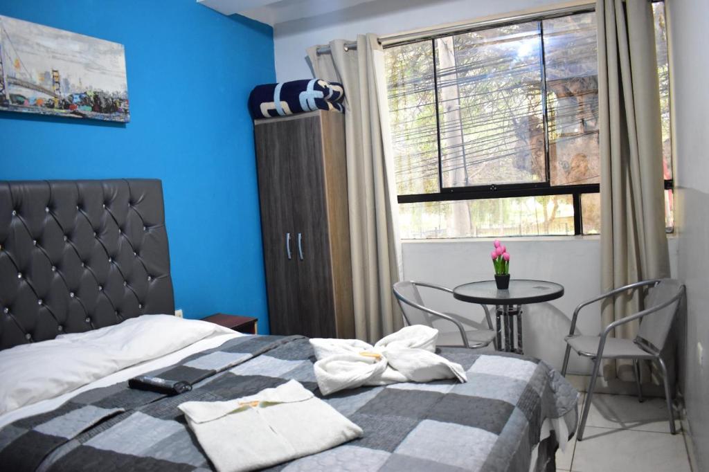 a bedroom with a bed and a table and a window at AYPA Hostal in Trujillo