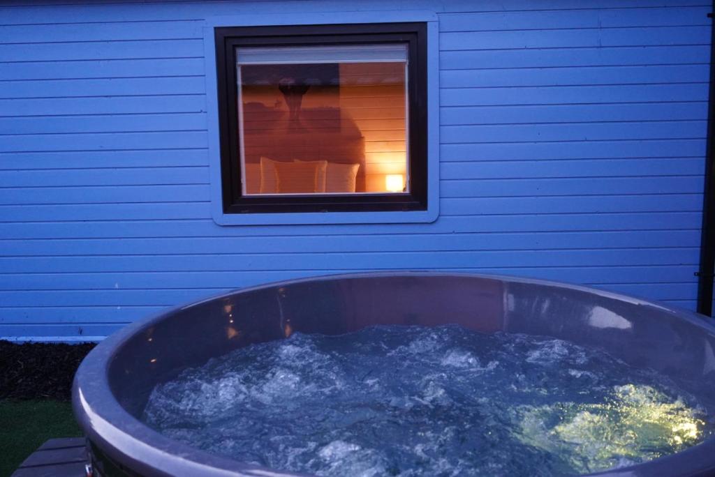 una gran bañera llena de agua junto a una ventana en West Wicklow Glamping with Hot Tub, en Baltinglass