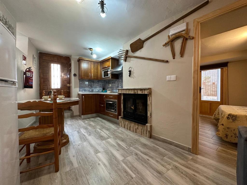 ein Wohnzimmer mit Kamin und eine Küche in der Unterkunft Casa Angel in Cazorla