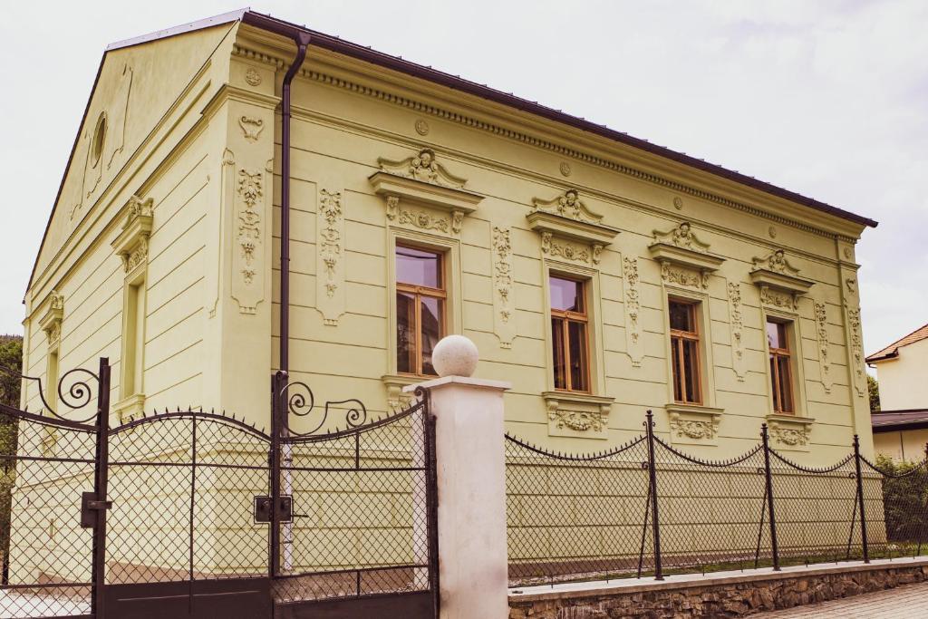 un edificio amarillo con una valla delante en Ubytování U Vladaře, en Velhartice