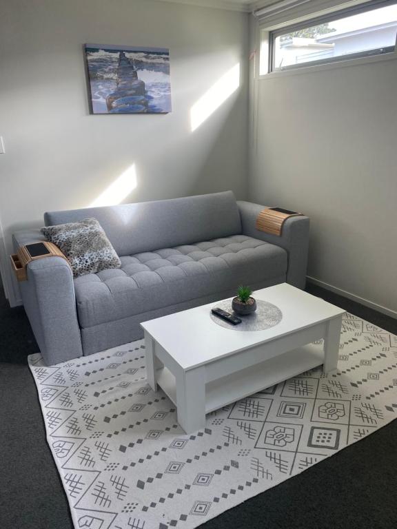 uma sala de estar com um sofá e uma mesa de centro em Bunker on Belt em New Plymouth