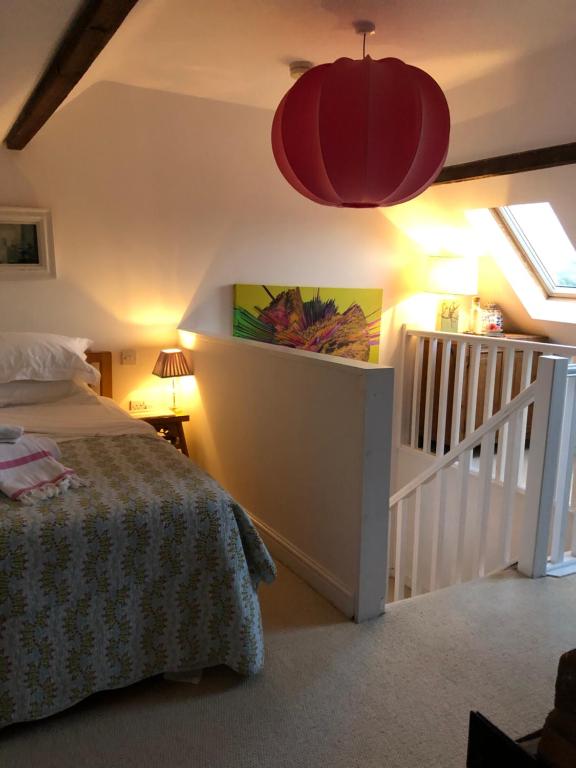 a bedroom with a bed and a red pendant light at Halday in Stafford