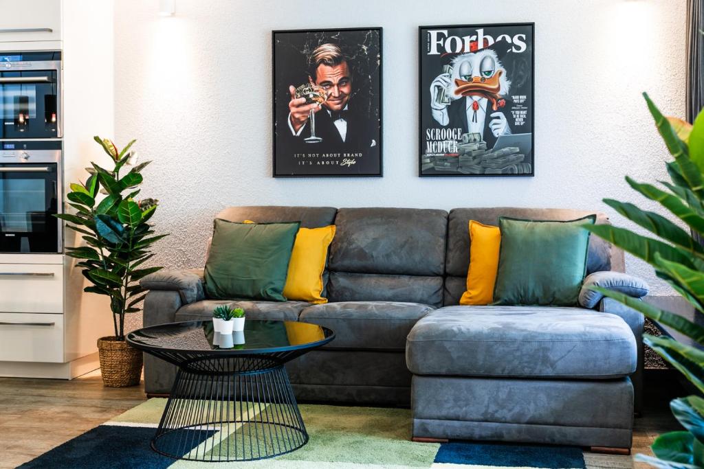 ein Wohnzimmer mit einem Sofa und zwei Plakaten in der Unterkunft Spirit Apartments - Suite #1 - Balkon - Bergsicht in Engelberg