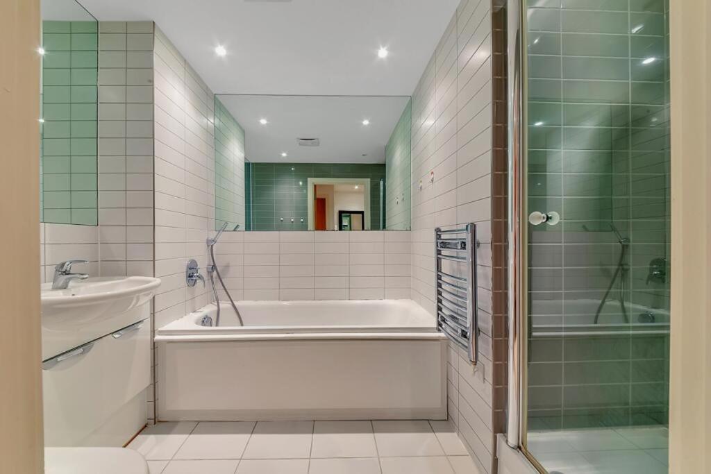 a bathroom with a tub and a sink and a shower at COZYCOMFY LUXURY APARTMENT in London