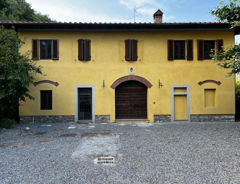 een geel huis met een deur en ramen bij A.G. Rooms in casa colonica in Vaiano