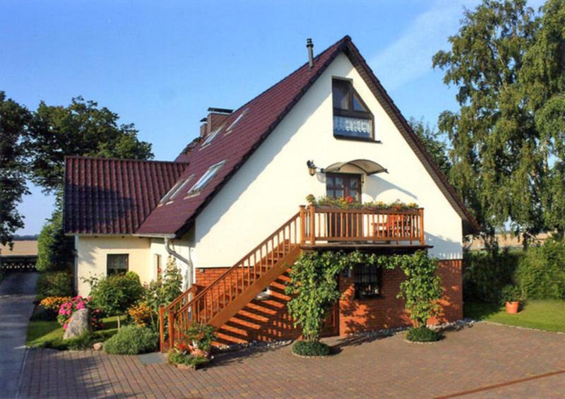 HohendorfFerienwohnungen im Altbauernhaus的白色的房子,设有甲板和阳台
