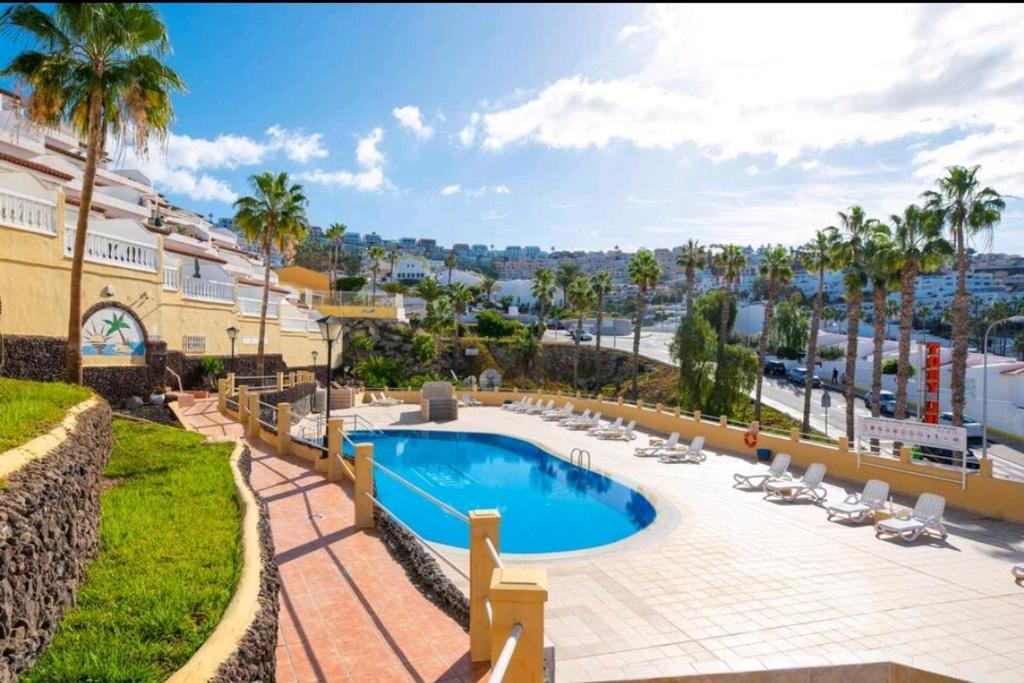 Ke Casetta Tenerife Anna Apartment في أديخي: مسبح وكراسي صالة ومنتجع