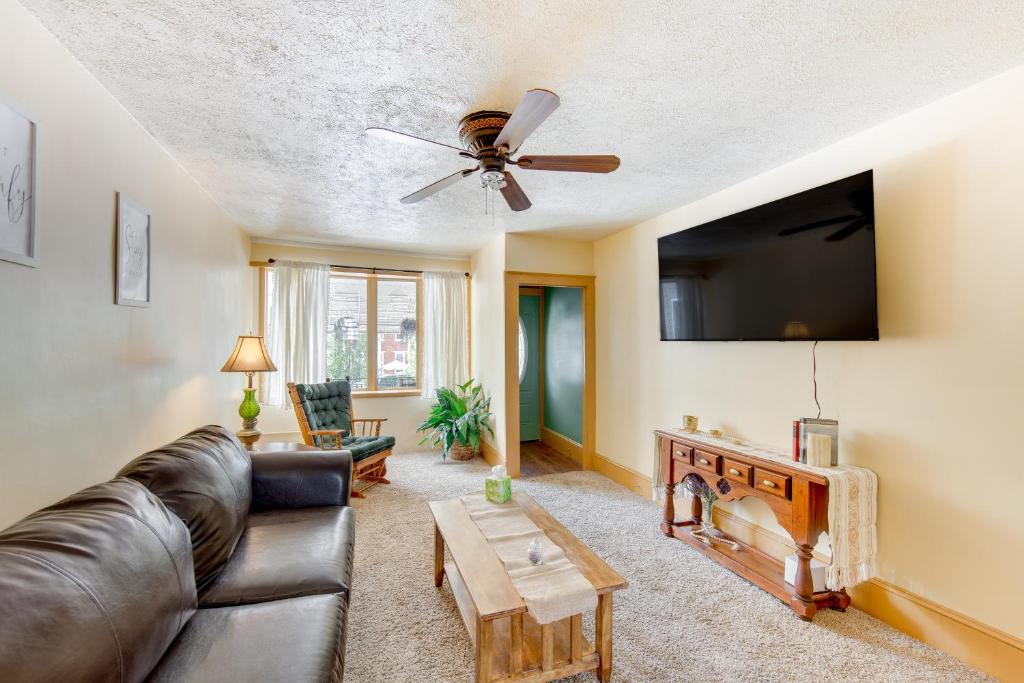 uma sala de estar com um sofá e uma ventoinha de tecto em Pet-Friendly Mt Carmel Vacation Rental with Yard! 
