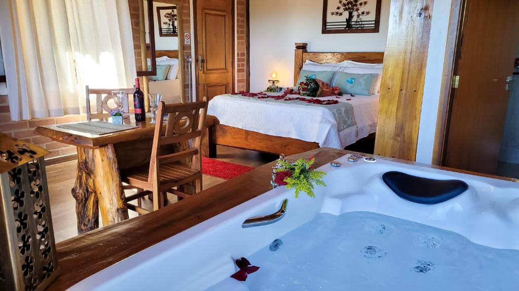 a bathroom with a tub and a bedroom with a bed at Pousada Chales Rancho Caipira in Santo Antônio do Pinhal