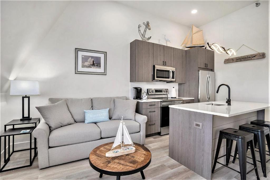 a living room with a couch and a kitchen at Black River Retreat in South Haven