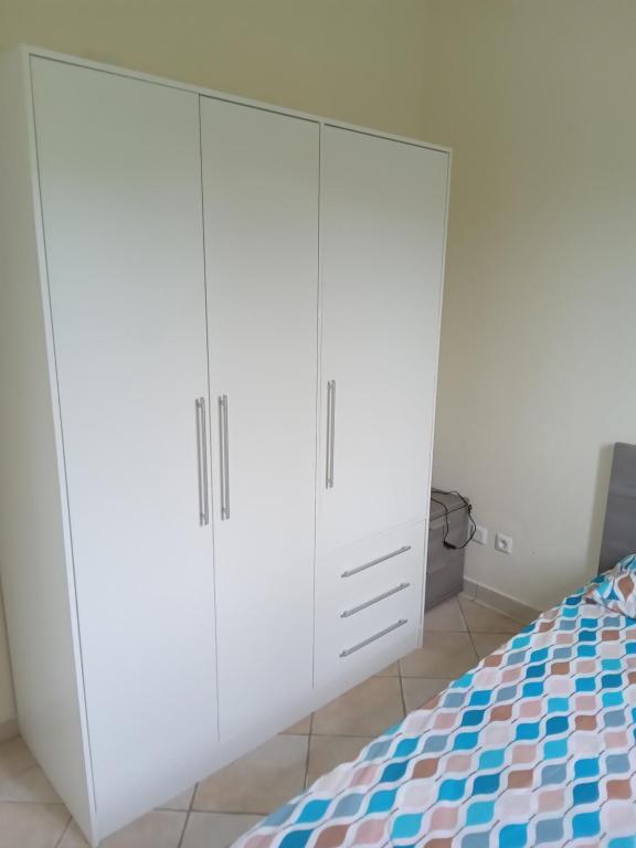 a bedroom with white cabinets and a bed at Maison zebre in Port-Louis