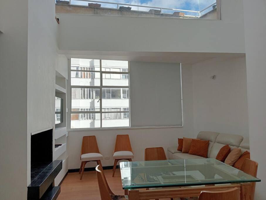 sala de estar con mesa de cristal y sillas en Apartamento Continental, en Bogotá