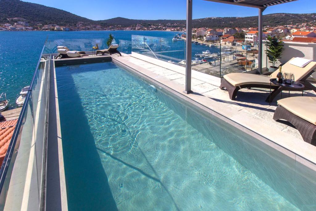 a swimming pool on a building with a view of the water at Seafront villa with roofpool, perfect getaway in Vinišće