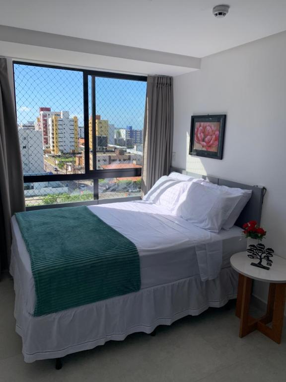 a bedroom with a large bed and a large window at Pérola do Bessa in João Pessoa