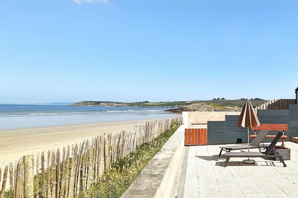 - un banc et un parasol sur la plage dans l'établissement Appartement pour 3 personnes Sur la plage Les pieds dans leau, à Plonévez-Porzay