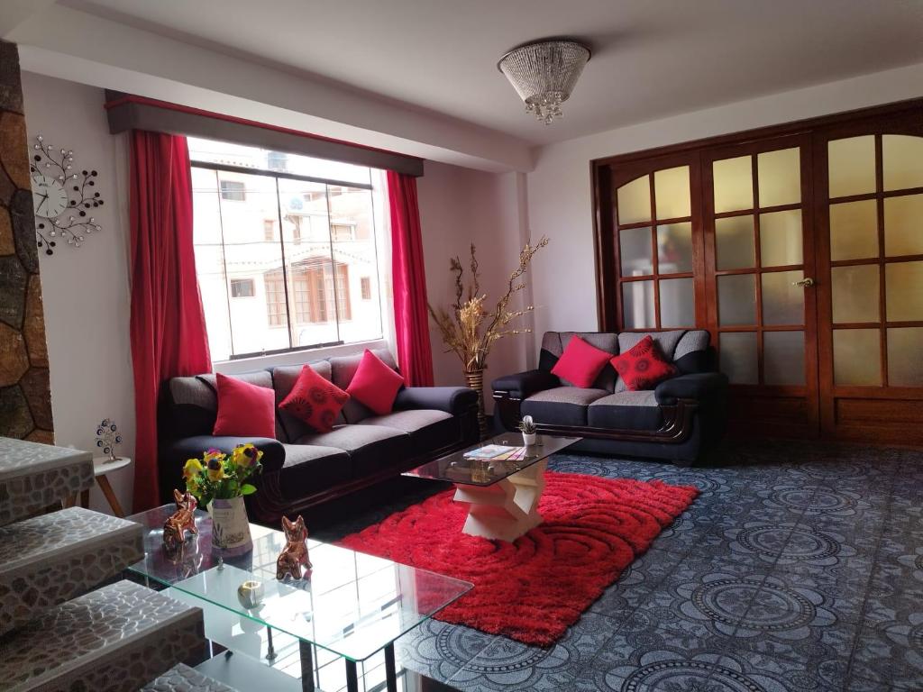 een woonkamer met 2 banken en een glazen tafel bij Valentina House in Tacna