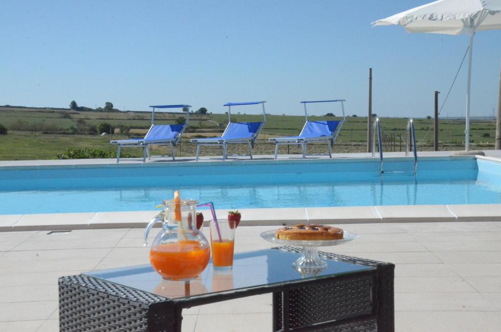 a table with drinks on it next to a swimming pool at Campagne Iblee in Ragusa