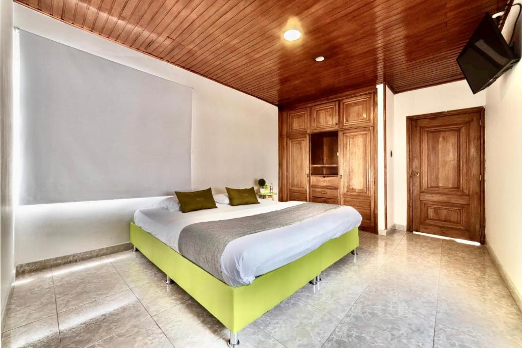 ein Schlafzimmer mit einem Bett und einer Holzdecke in der Unterkunft Hotel Quintas de Normandia in Bogotá