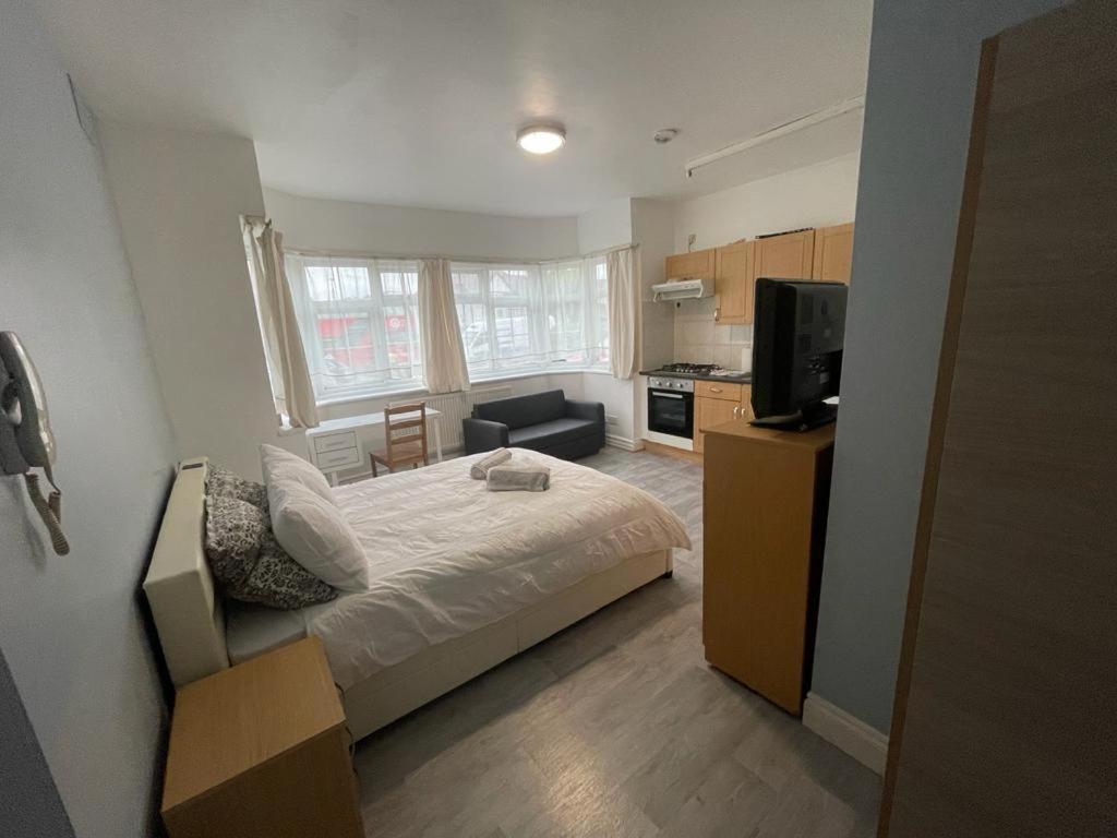 a small bedroom with a bed and a kitchen at New Studio on Golders Green RD in London