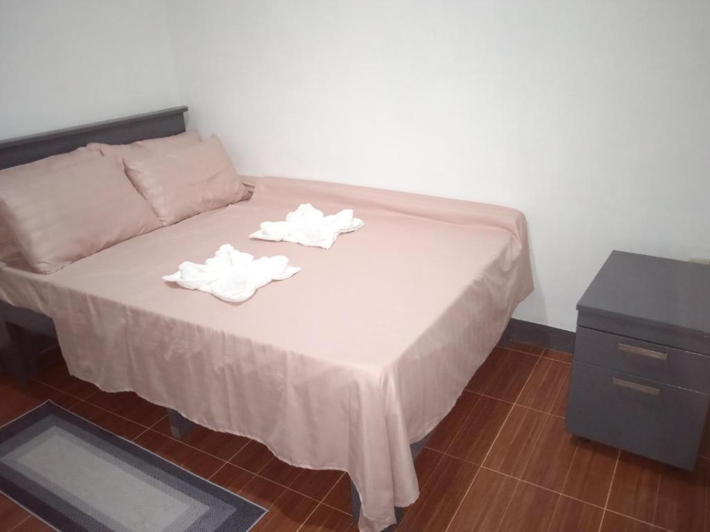 ein Bett mit zwei weißen Handtüchern darüber in der Unterkunft Sarah's Garden BnB & Spa in Clarin