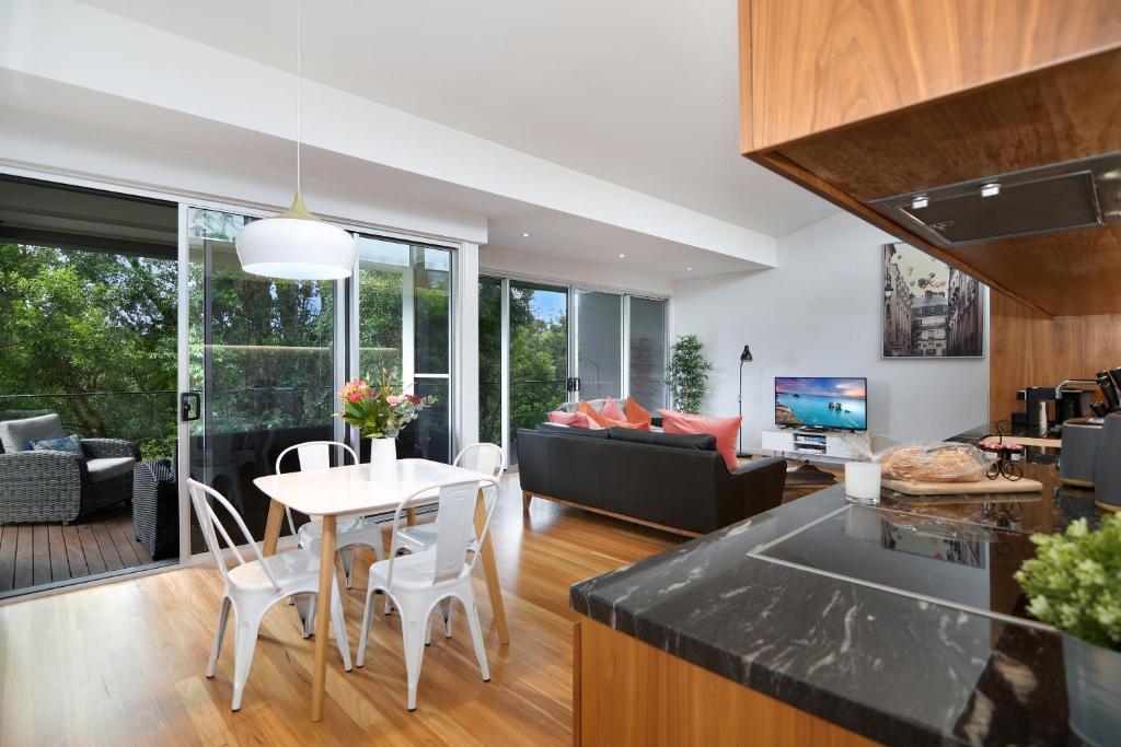 une cuisine et un salon avec une table et des chaises dans l'établissement Coral Villa, à Maleny