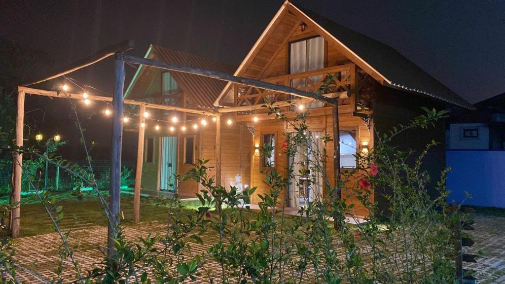 drewniany dom z oświetleniem w nocy w obiekcie Pousada Chalé Flor de Hibisco 3 w mieście Penha