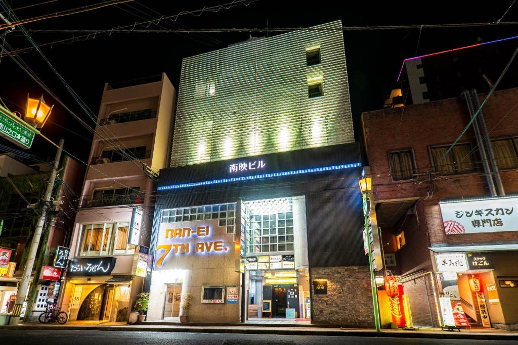 un grupo de edificios en una calle de la ciudad por la noche en NanEi Building, en Kagoshima