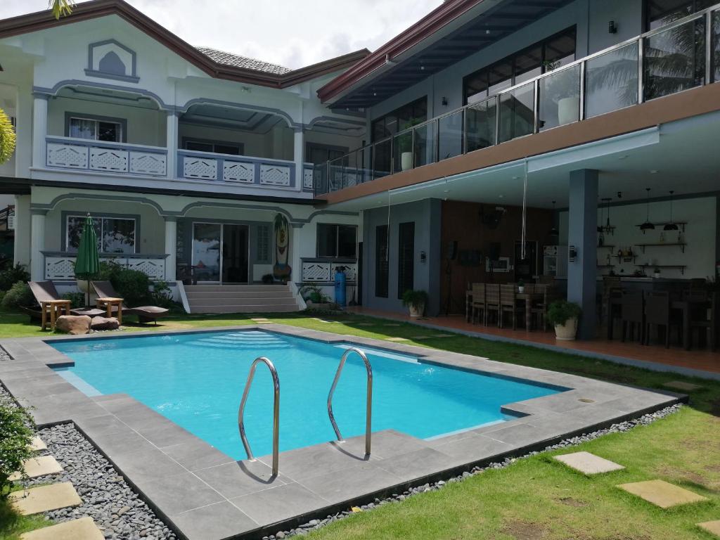 a swimming pool in front of a house at Baki Divers and Beach Resort in Dauin