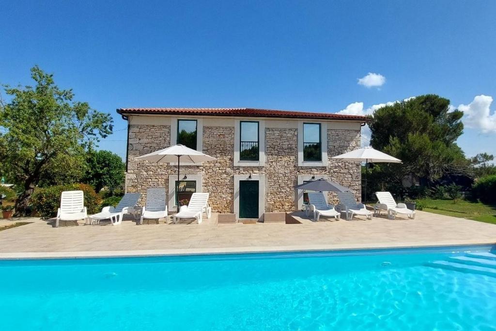 a villa with a swimming pool in front of a house at Family-friendly apartments with swimming pool Pomer, Medulin - 17681 in Pula