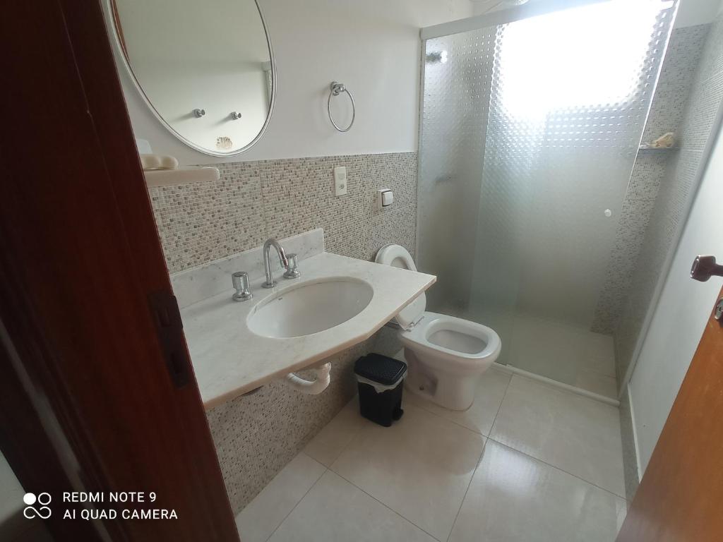 bagno con lavandino, servizi igienici e specchio di Casa das posses para 8 pessoas a Serra Negra