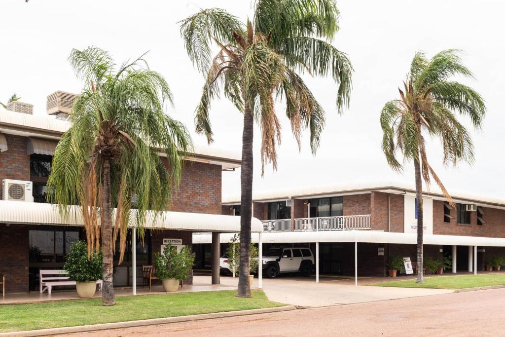 un edificio con palmeras delante en Longreach Motor Inn, en Longreach