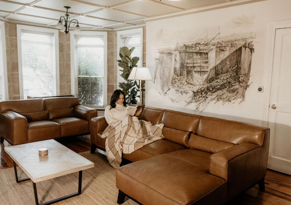 Eine Frau auf einer Couch im Wohnzimmer in der Unterkunft The Rose Turret in Warrnambool