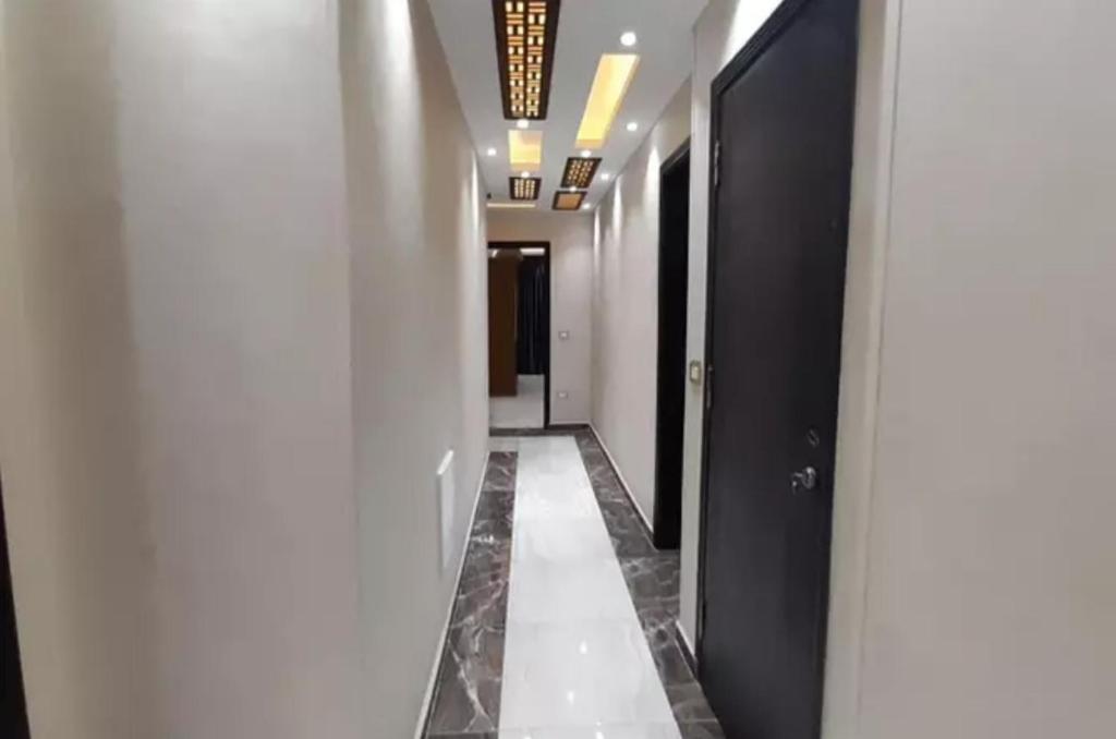 a hallway with white walls and a black door at the house in Cairo