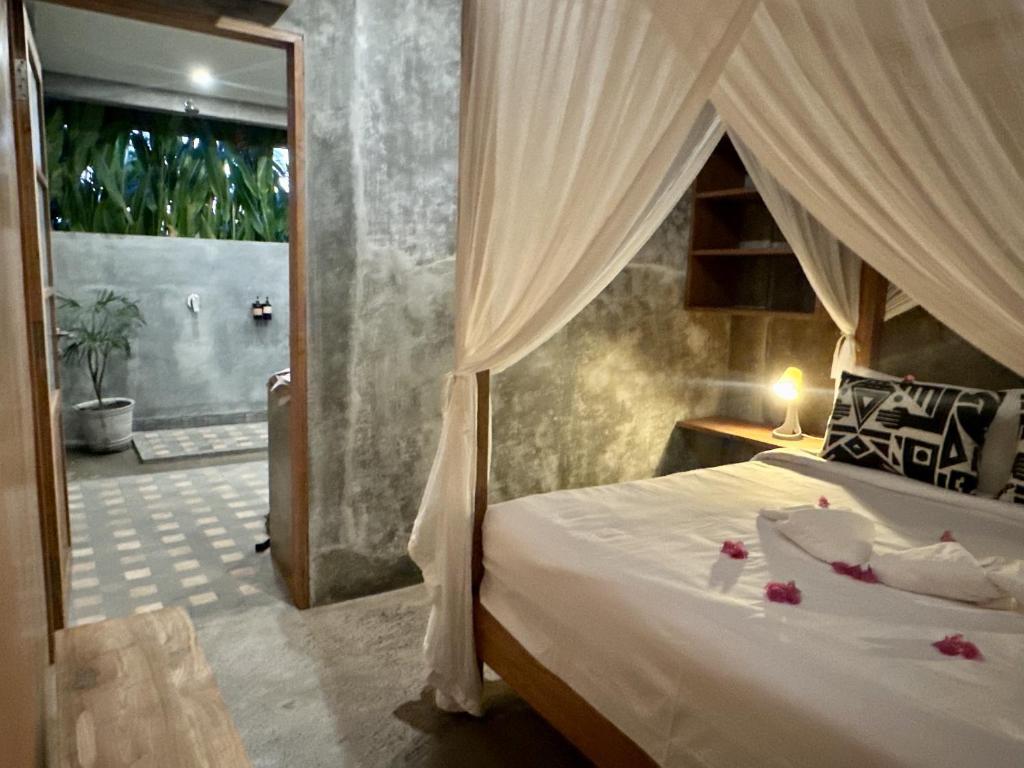 a bedroom with a bed and a bathroom with a shower at Mangroove Bay Boutique Hostel in Banyuwedang
