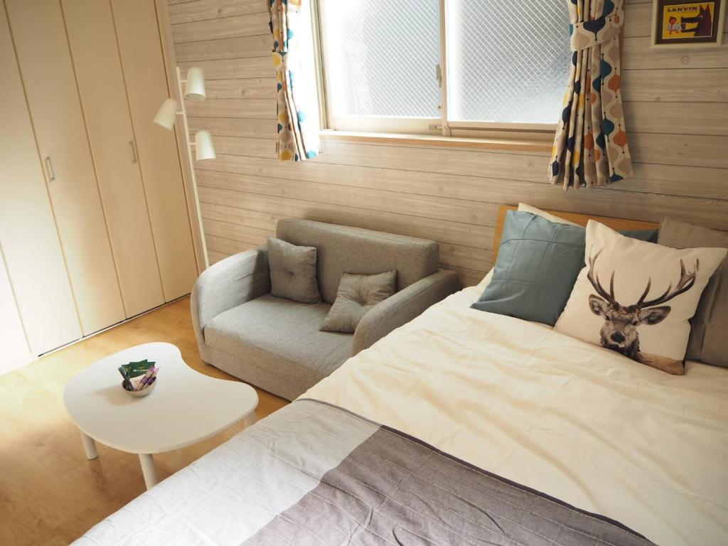 a bedroom with a bed and a couch and a table at City Oasis in Tokyo