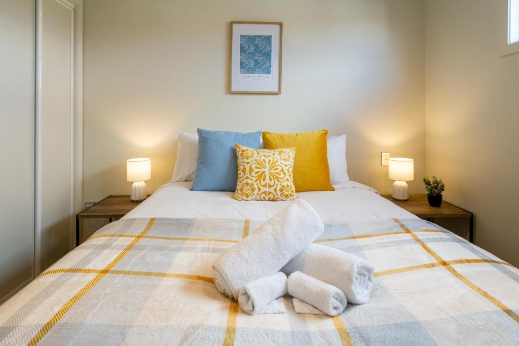 a bedroom with a large bed with towels on it at The Cozy Cocoon 1 Bed 1 Bath Apartment in Christchurch