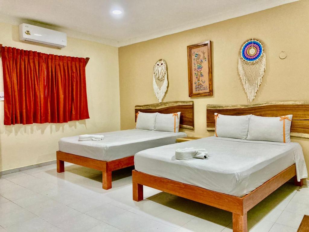 - une chambre avec 2 lits et un rideau rouge dans l'établissement Casa Yaxkin, à Valladolid