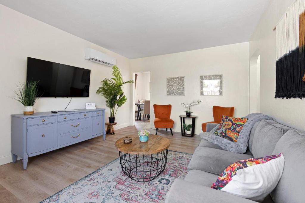 uma sala de estar com um sofá e uma televisão em Enchanting cozy Apartment 10 min away from airport, Calle 8, Brickell, Coral Gables, the beach and more! em Miami